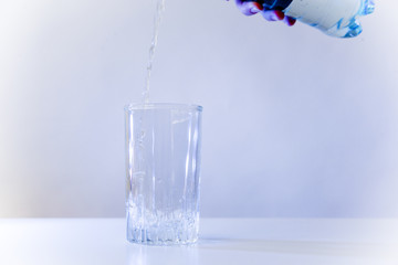 Glass of pure water on a white kitchen table