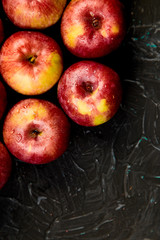 Fresh organic red apples on black background.