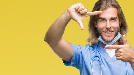 Young handsome doctor man with long hair over isolated background smiling making frame with hands and fingers with happy face. Creativity and photography concept.