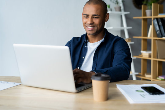 Image of african american businessman working on his laptop. Handsome young man at his desk