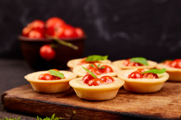Mini tarts with cherry tomatoes with mozzarella cheese