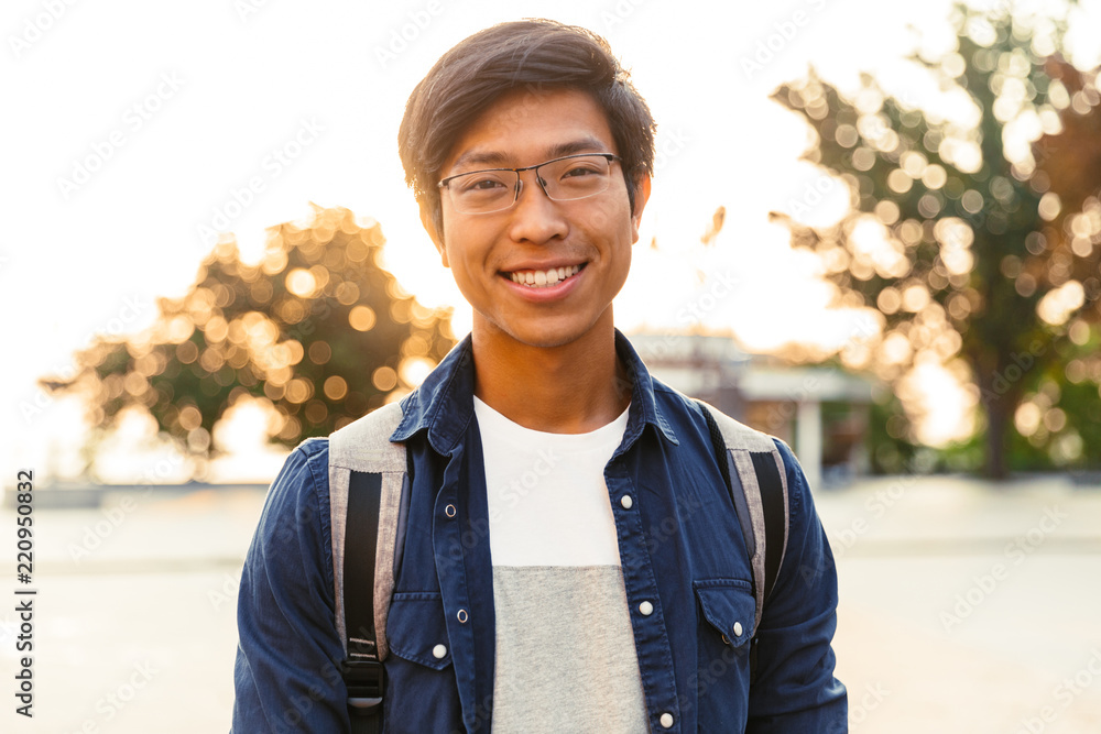 Wall mural Picture of Joyful asian male student in eyeglasses