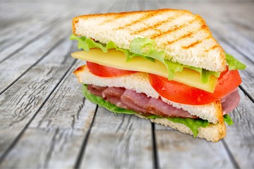 Fresh tasty sandwiches on wooden background