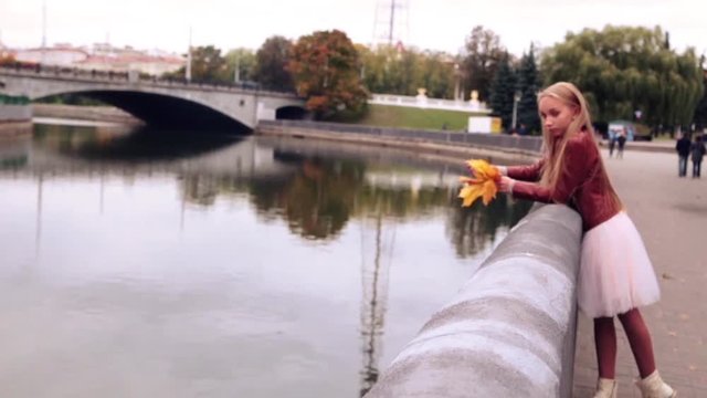 beautiful teenage girl throws leaves