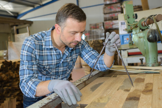 artisan measuring a plank