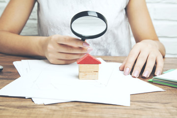 Businesswoman hand magnifier and house model