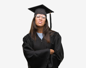 Young hispanic woman wearing graduated cap and uniform skeptic and nervous, disapproving expression on face with crossed arms. Negative person.
