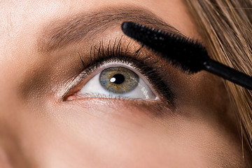 partial view of attractive woman and mascara brush
