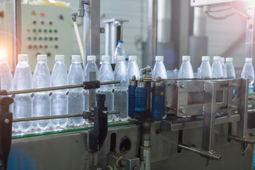 Factory and production concept - conveyor for bottling water from plastic bottles