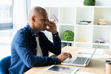 Image of african american businessman working on his laptop. Handsome young man at his desk