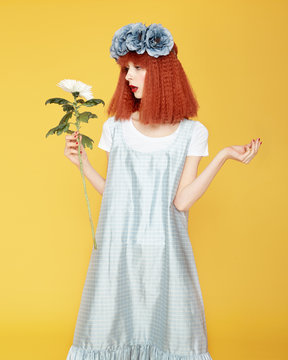 Charming woman in dress holding flower