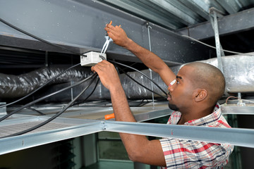 Man fitting cables into a junction box