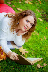  woman reading a book   in the autumn park