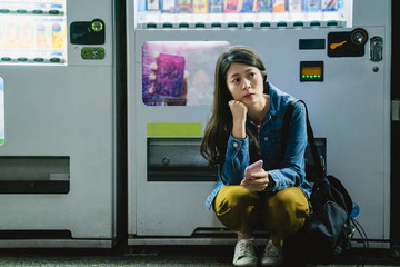 girl squatting down and holding her phone