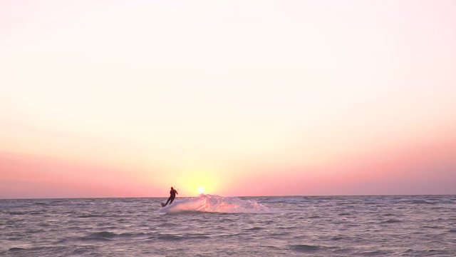 Slow-motion shooting alone kiter at dawn performs a stunt in the air