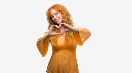 Young redhead woman smiling in love showing heart symbol and shape with hands. Romantic concept.