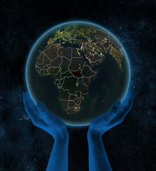 South Sudan on night Earth in hands