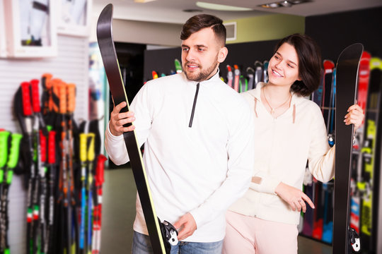 Couple choosing skis in shop