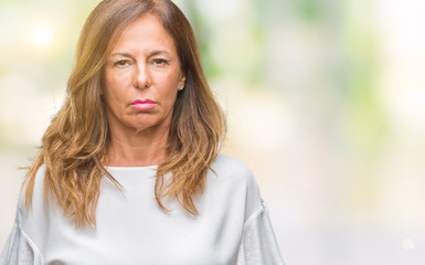 Obraz premium Middle age senior hispanic woman over isolated background with serious expression on face. Simple and natural looking at the camera.