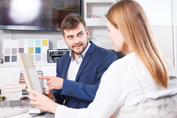 Girl consulting with salesman in furniture salon