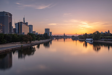 Fototapeta premium Frankfurter Skyline bei Sonnenaufgang über dem Main, Blick auf das Bankenviertel - Sonnenaufgang in Pastellfarben