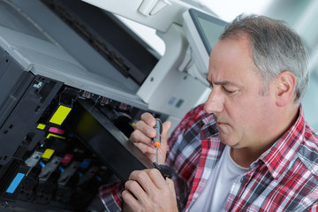 Naklejka na ściany i meble man technician repairing a printer at business place at work