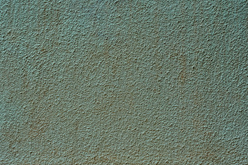 Old stucco wall painted with green paint