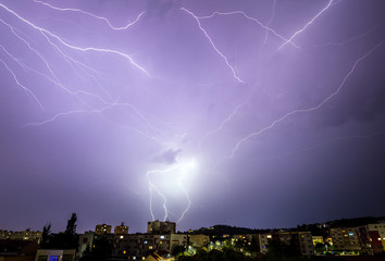 Naklejka na ściany i meble extreme weather storm and glimmer lightning over the city town 