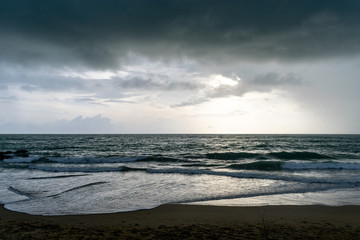 A landscape of a beach on a stormy day, with lots of grey or gray clouds