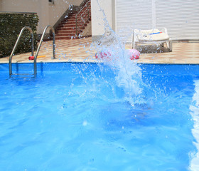 water splashes after the kid's jump into the pool