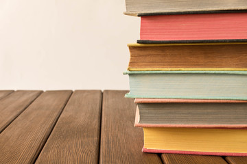 Stack of books on a wooden table. The concept of education and knowledge from books. Close up. With empty space for text