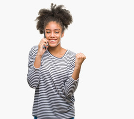Young afro american woman talking on the phone over isolated background screaming proud and celebrating victory and success very excited, cheering emotion