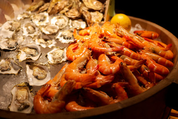 Assortment of tasty and delicious seafood on ice, oyster and and banana prawn. Contain cholesterol, but low in saturated fat and also have omega-3 fatty acid. Healthy eating.