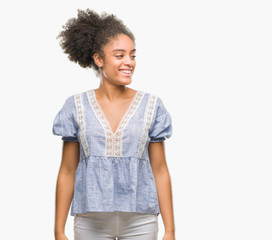 Young afro american woman over isolated background looking away to side with smile on face, natural expression. Laughing confident.