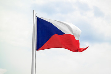 Czech Republic flag on a blue sky with clouds background