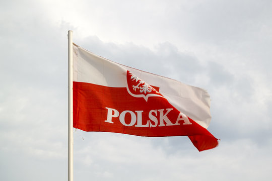Poland flag on a blue sky with clouds background