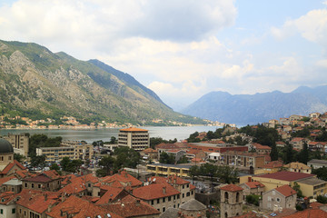 Fototapeta na wymiar view of medieval tiled roofs of stone houses with windows and wooden shutters in the old town of Kotor, Montenegro