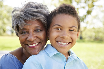 Portrait Of Grandmother With Grandson Relaxing In Park