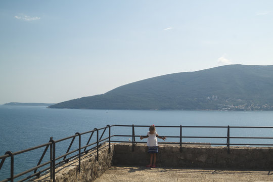 frowned girl is depicted on the observation deck with a breathtaking spectacular view of the Boka-Kotorska bay from the fortress Herceg Novi, Montenegro