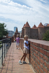 Fototapeta na wymiar Outdoor portrait of young beautiful boy and girl posing on old street. Old Warsaw, Poland, summer