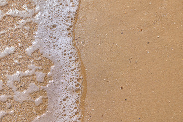 Soft wave of the sea on the sandy beach as background