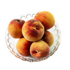 A Bowl of Peaches in a Glass Bowl Isolated on a White Background