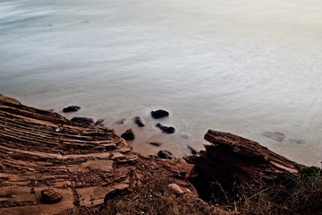 una roca y el mar detrás con larga exposición 