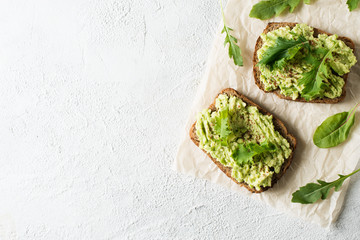 Toasts with avocado and green salad on breakfast