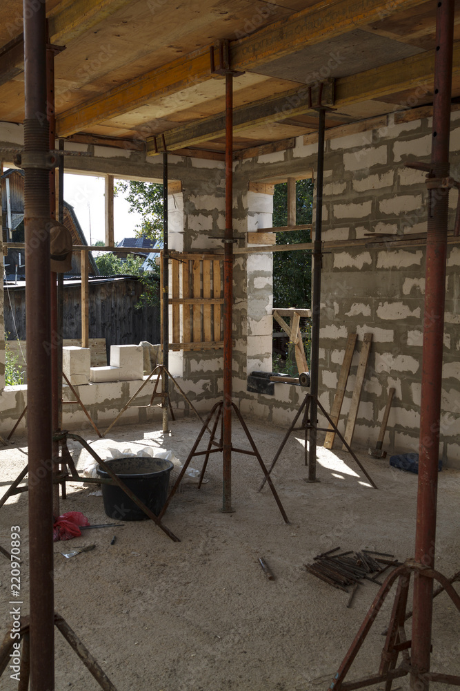 Poster view of the wooden formwork with metal holders, which will be filled with the overlap between the floors in the country house under construction from the foam block