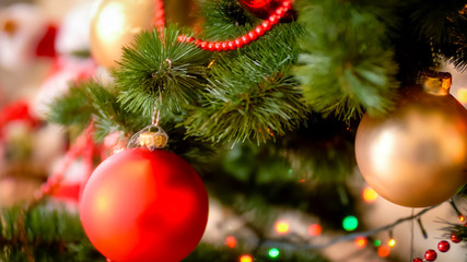 Obraz na płótnie Canvas Closeup image of red baubles and beads adorning Christmas tree
