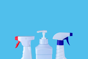 Bottle and sprays for cleaning the house on a blue background. Cleaning products, copy space