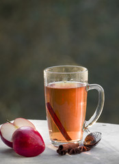 A cup of tea with red apples and cinnamon