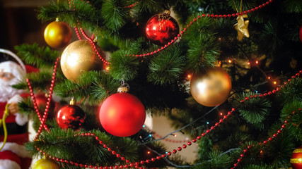 Closeup image of adorned Christmas tree with golden and red baubles
