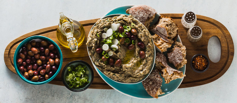 banner of Appetizer with baba ganush of eggplant, olives from kalamata, green onions and fresh rye bread. Mediterranean snack. Vegan healthy food